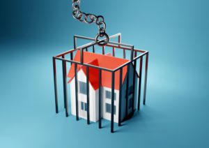 A house trapped in a caged prison. Mortgage, home owner trapped concept.