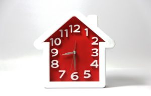 house shaped alarm clock - an article on how long it takes to sell a house.